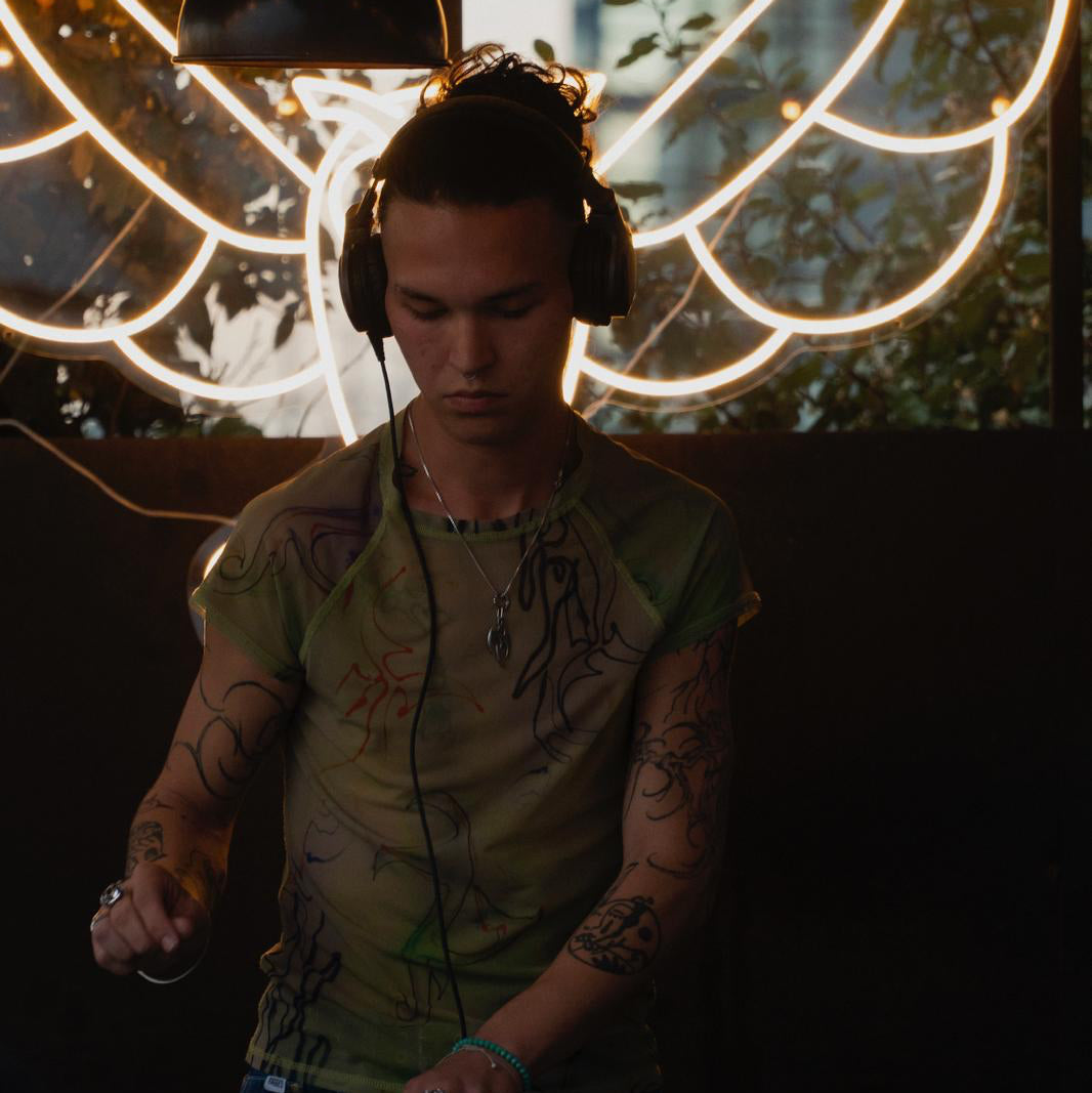 Miguelito (@miguel.shr), Hardgroove DJ from Düsseldorf, performing a deep and energetic set surrounded by warm neon lights and club vibes.